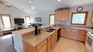 A modern kitchen with granite countertops, wooden cabinets, a built-in oven, and a coffee maker. - Great Dock, Wifi!  Come Visit "Captain's Choice"! (Huddleston)