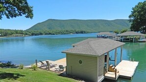 A small cabin with a dock, surrounded by a lake and hills. - Great Dock, Wifi!  Come Visit "Captain's Choice"! (Huddleston)