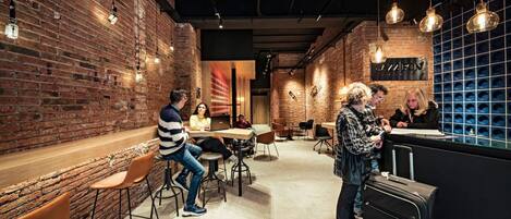A modern interior with brick walls, hanging pendant lights, and a bar area.