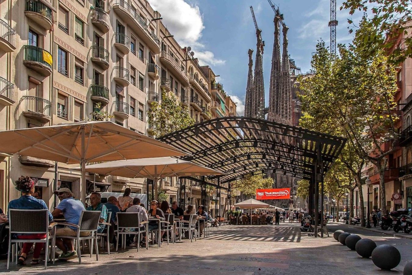 Une rue bordée de terrasses, dotée d’une allée couverte et de bâtiments avec des balcons.