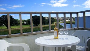 A balcony with a table and chairs, overlooking a river and greenery. - Waterside Cottage Wadebridge River views Camel Trail Cycling Free Wi-Fi Cornwall (Wadebridge)