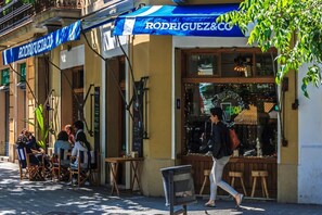 En butiksfacade med et blåt markise, hvor der står 'RODRIGUEZ&C'.
