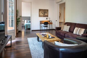 A living room with a sofa, coffee table, and a television. - Barcelona Balconies 10 - Habitat Apartments (Barcelona)
