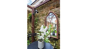 A rustic outdoor seating area with a metal table and a potted plant. - Modern, Chic 3BR Townhouse in Central Oxford - Pass the Keys (Oxford)