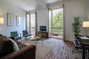 A modern living room with a sofa, chairs, a coffee table, a TV, and a balcony with a view. - Barcelona Balconies 12 - Habitat Apartments (Barcelona)