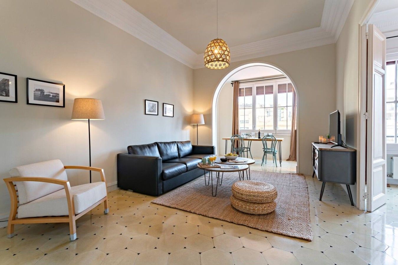 Ein Wohnzimmer mit Sofa, Sessel, Couchtisch und Fernseher.