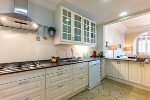 A modern kitchen with white cabinetry, a gas stove, and a dishwasher.