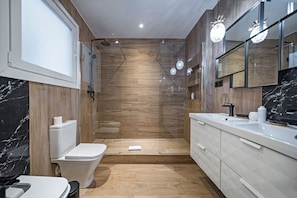 A modern bathroom with a shower, toilet, and sink.