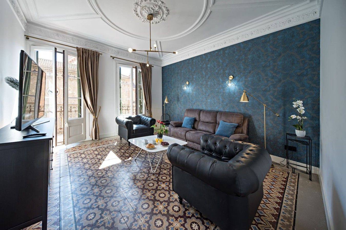 A living room with a patterned floor, a sofa, a coffee table, and a television.