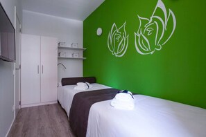 A hotel room with a bed, a wardrobe, and a green wall with a white floral design. - Chic Sants Gem ADN 21 (Barcelona)