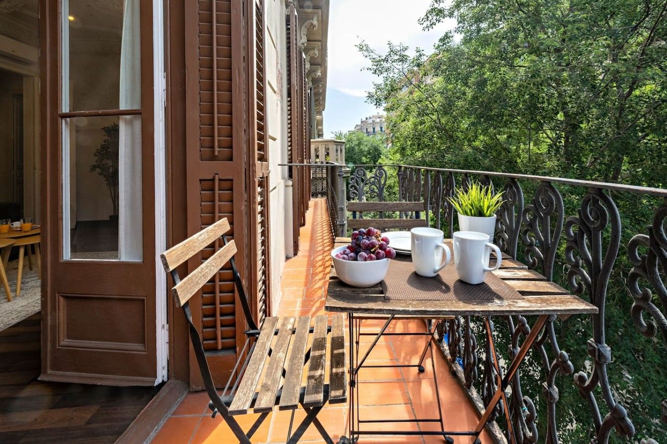 A balcony with a wooden table, a bench, and a railing.