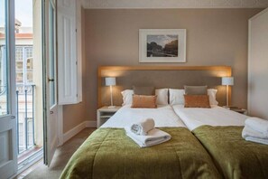 A hotel room with a double bed, two bedside tables, a window, and a framed picture on the wall.