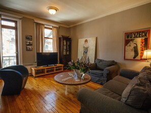 Een woonkamer met een televisie, bank en salontafel.