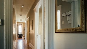 A hallway with wooden flooring, white walls, and a large mirror on the right. - Montreal Plateau Mont Royal: apartments - 5 rooms - 4/6 persons (Montréal (Plateau Mont-Royal))
