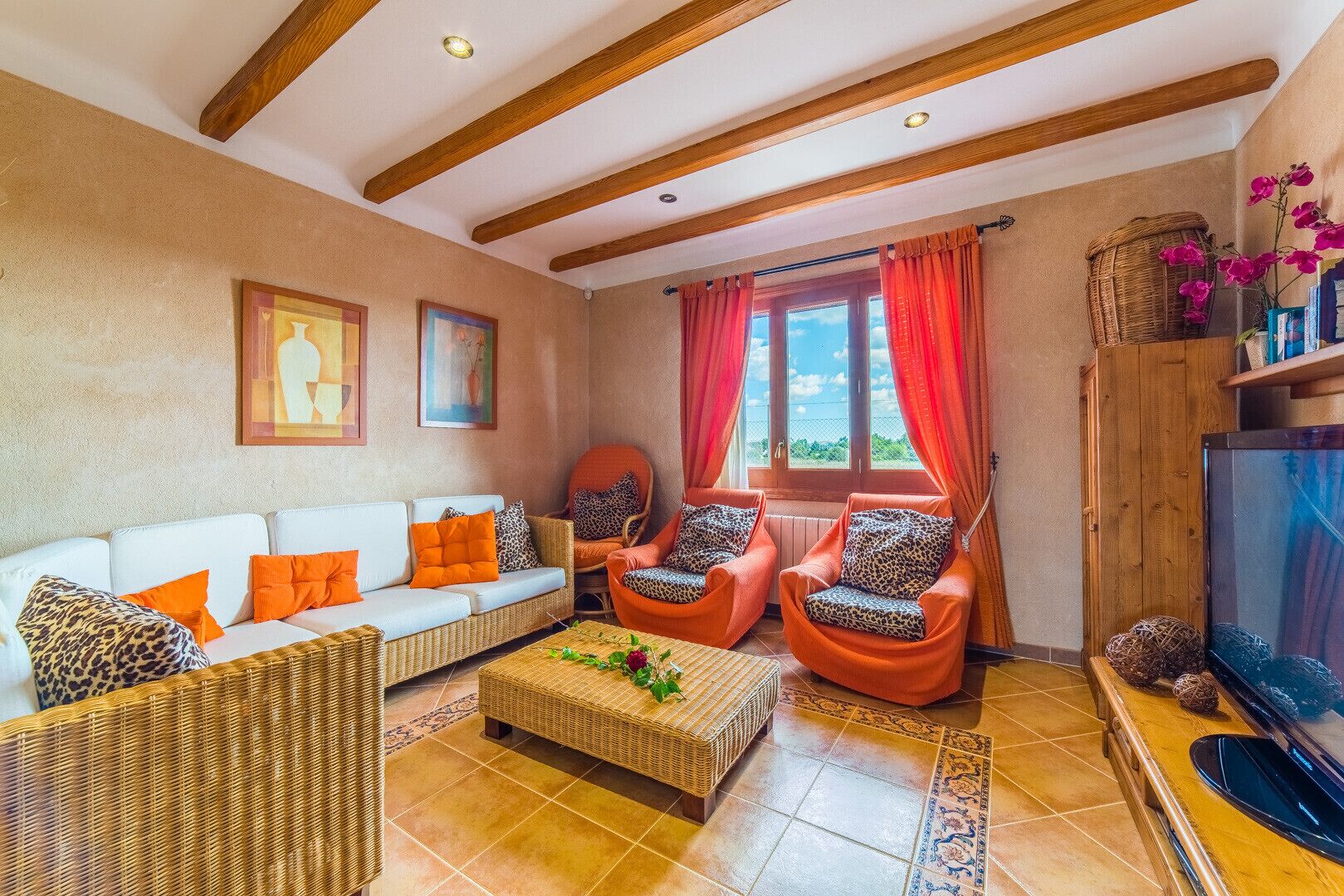 Un salon comprenant un canapé, deux fauteuils, une table basse et un téléviseur.