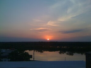 A sunset over a body of water with a distant horizon. - Gallery Loft Riverview Rooftop Terrace Elevator (Vicksburg)