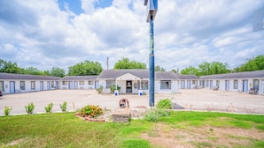 A motel with a central building and multiple attached units. - OYO Budget Inn Falfurrias Hwy 281 (Falfurrias)