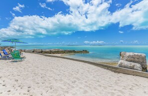 En la playa, camastros, sombrillas y toallas de playa 