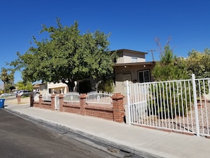 A residential property with a gated entrance, a brick wall, and a tree in front. - STATE/CITY LICENSED AND PERMITTED! 3 bed 2 bath Single Family Home Pet Friendly. (Las Vegas)