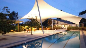 Une piscine dotée d’une structure architecturale moderne en arrière-plan.