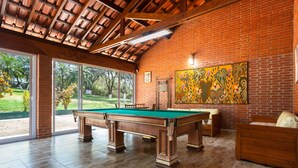 A pool table in a room with brick walls and large windows. - Place with complete leisure 100km from São Paulo (Porto feliz)