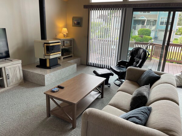 A living room with a wooden coffee table, a sofa, a TV, and a fireplace. - The San'Bar - Great Family Home Just A Short Walk To York's Beautiful Beaches (York)