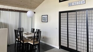 A dining area with a wooden ceiling, a white ceiling fan, a framed photo on the wall, and a sign indicating the direction to the beach. - The San'Bar - Great Family Home Just A Short Walk To York's Beautiful Beaches (York)