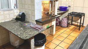 Una cocina con encimera de granito, estufa a gas, un bote de basura y ventana con vistas al exterior.
