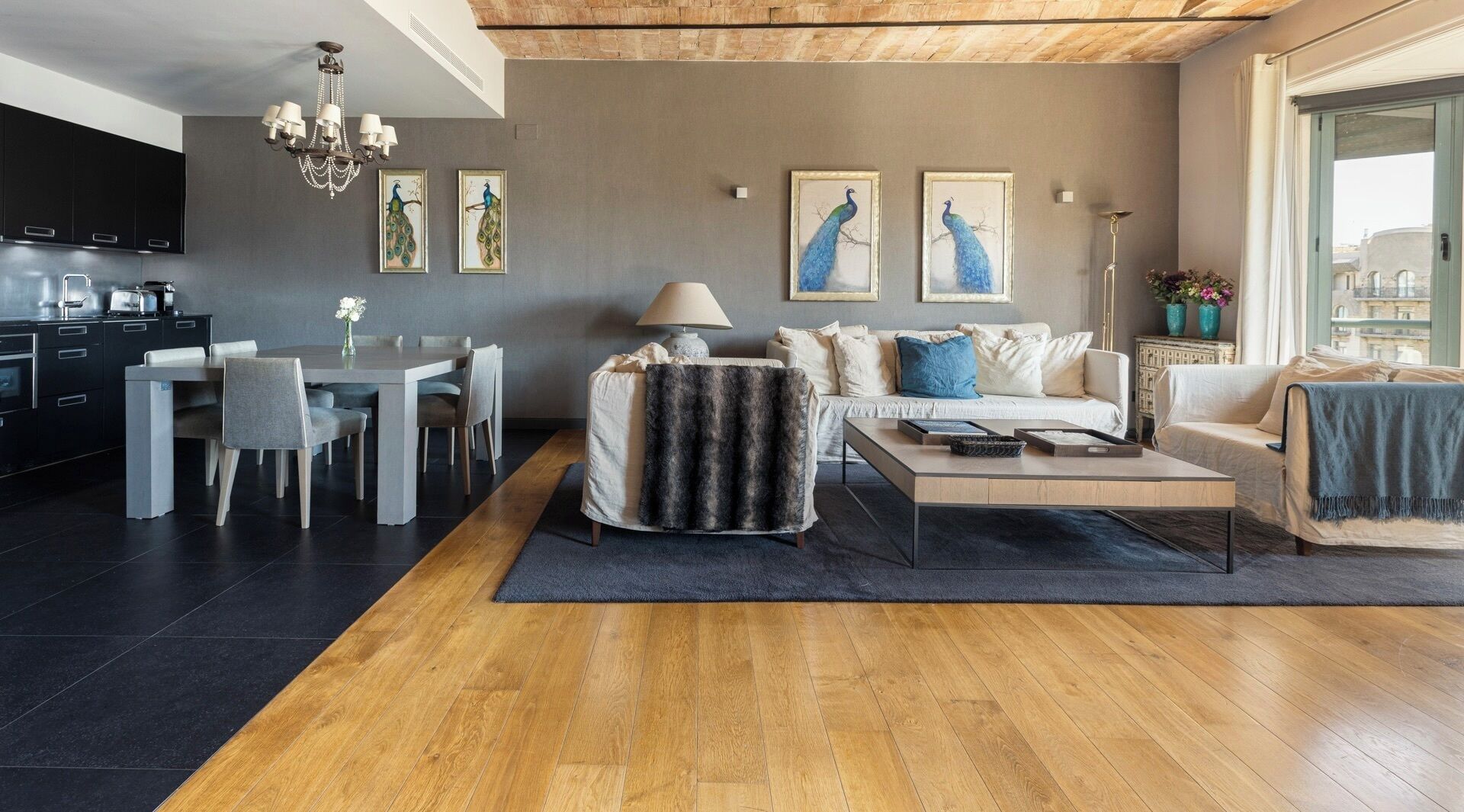 Ein modernes Wohnzimmer mit Essbereich, einer Couch, einem Couchtisch und Kunstwerken an der Wand.