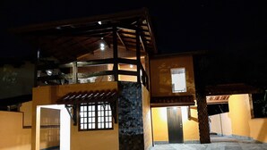 A two-story building with a balcony, a door, and a window. - Beautiful house with pool and great location (Caraguatatuba)