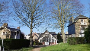A traditional house with a large tree in front, a well-maintained lawn, and a clear blue sky. - The Sea Cottage (Villerville)