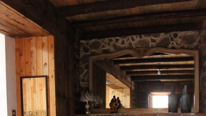 A bedroom with a stone wall, wooden ceiling, and a bed with a blue and white patterned bedspread. - COMFORTABLE BEDROOM SALAM FURNISHED OF 25 M2 BUILT IN A HOUSE OF THE XVII CENTURY (Jocotitlan, MEX)