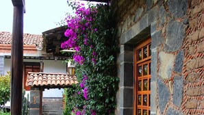 A stone pathway leading to a building with a wooden door and a tiled roof. - COMFORTABLE BEDROOM SALAM FURNISHED OF 25 M2 BUILT IN A HOUSE OF THE XVII CENTURY (Jocotitlan, MEX)