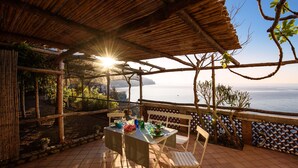An outdoor terrace with a table set for dining, overlooking a body of water. - UVA, Pagliarulo Complex by AMALFIVACATION.IT, Pool, Sea View, 2 Terraces (RAVELLO)