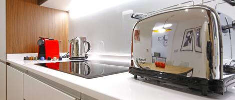 Eine Küche mit Toaster, Wasserkocher und Kaffeemaschine auf der Arbeitsfläche.