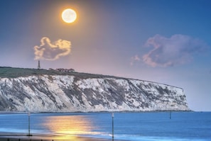 A coastal landscape with a prominent cliff, a lighthouse, and a building on top. - Seaways, in Sandown,for a great relaxing holiday, Family friendly, free parking (Isle of Wight)