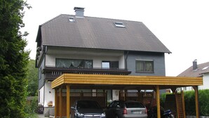 Une maison à deux étages avec un abri-voiture couvert.