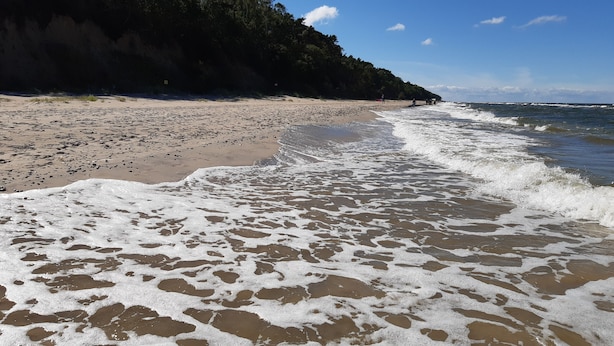 Uma praia com areal e ondas.