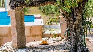 A stone structure with a tree trunk and a hanging object. - Rural Villa in Mallorca Ses Comes with pool (Selva)