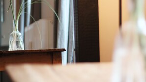 A table with a vase of plants, a lamp, and a blurred background. - Stylish design apartment (Trier)