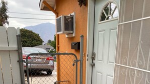 A gated entrance with a car parked inside, a potted plant, and a door with a mesh screen. - 20 minutes from downtown San Diego.Large clean quiet secured studio.Near 54H 125 (Spring Valley)