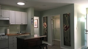 A compact kitchen with white cabinets, a wooden countertop, and a built-in stove. There are two stools at a small bar area. The room has light green walls and a carpeted floor. - 20 minutes from downtown San Diego.Large clean quiet secured studio.Near 54H 125 (Spring Valley)