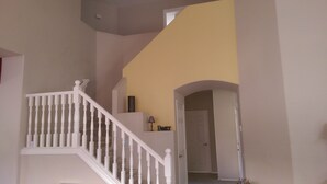 A staircase with white balusters leading to a landing with a lamp and a sign that reads "FAMILY". - Classy and Comfortable, Gated 4-Bdrm Home, Heated Pool Family-Friendly (Mesa)