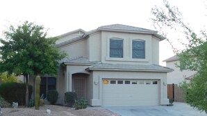 A two-story house with a garage, a driveway, and a well-maintained garden with cacti and shrubs. - Classy and Comfortable, Gated 4-Bdrm Home, Heated Pool Family-Friendly (Mesa)