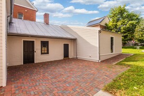 A single-story house with a brick patio and a garage. - Gorgeous 1840 Log Cabin- Downtown (Frederick)