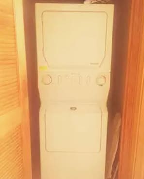 A white washing machine in a wooden cabinet.