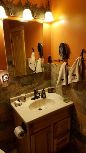 Een bad/douchecombinatie, een haardroger, handdoeken, zeep