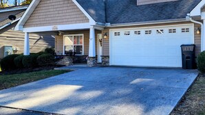 A two-story house with a garage, a covered porch, and a small window above the garage. - Believe N Dreams #317 – Your Peaceful Retreat in the Heart of Pigeon Forge (Pigeon Forge)