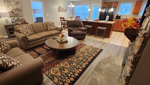 A modern living room with a brown sofa, patterned cushions, a coffee table, and a patterned rug. - Believe N Dreams #317 – Your Peaceful Retreat in the Heart of Pigeon Forge (Pigeon Forge)