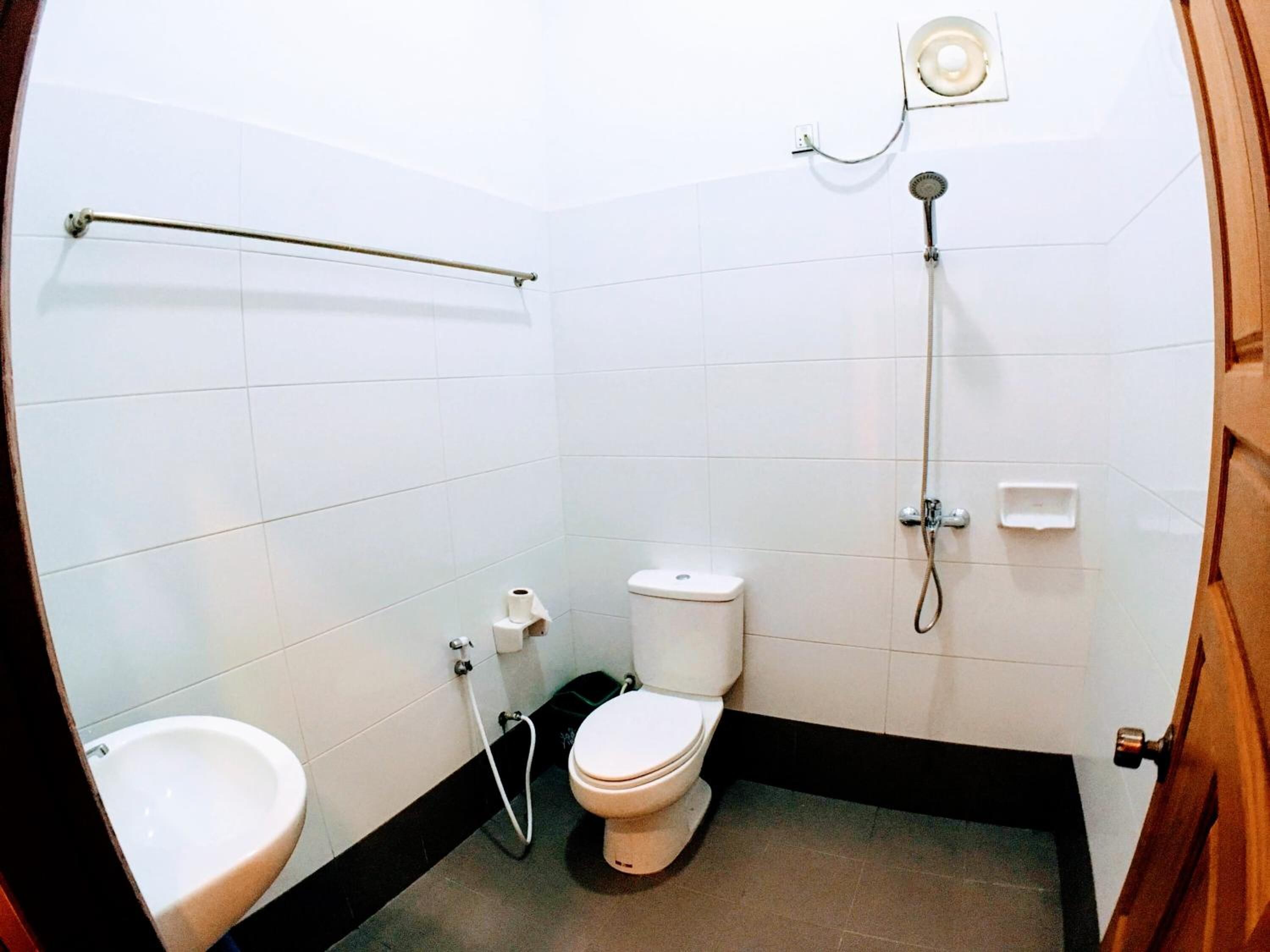 A small, clean bathroom with a toilet, bidet, and shower.